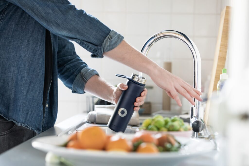 person fills up water bottle with filtered tap water