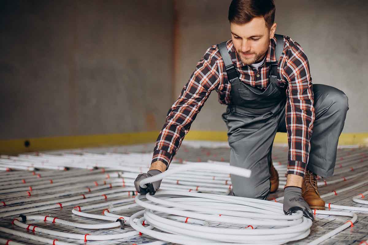 service man installing house heating system floor