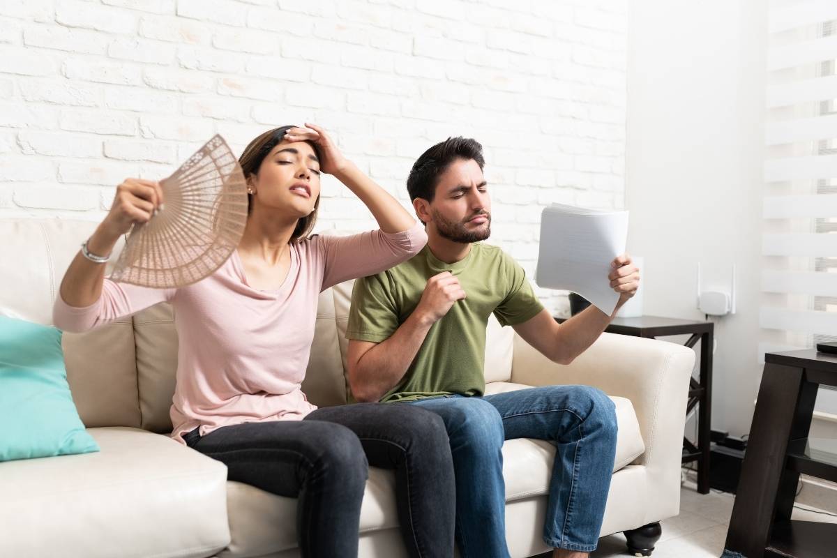 two people on couch try to stay cool this summer