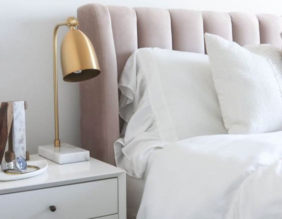 ash rose headboard with white pillows and gilded table lamp