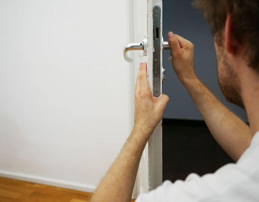 locksmith checking door's lock mechanism