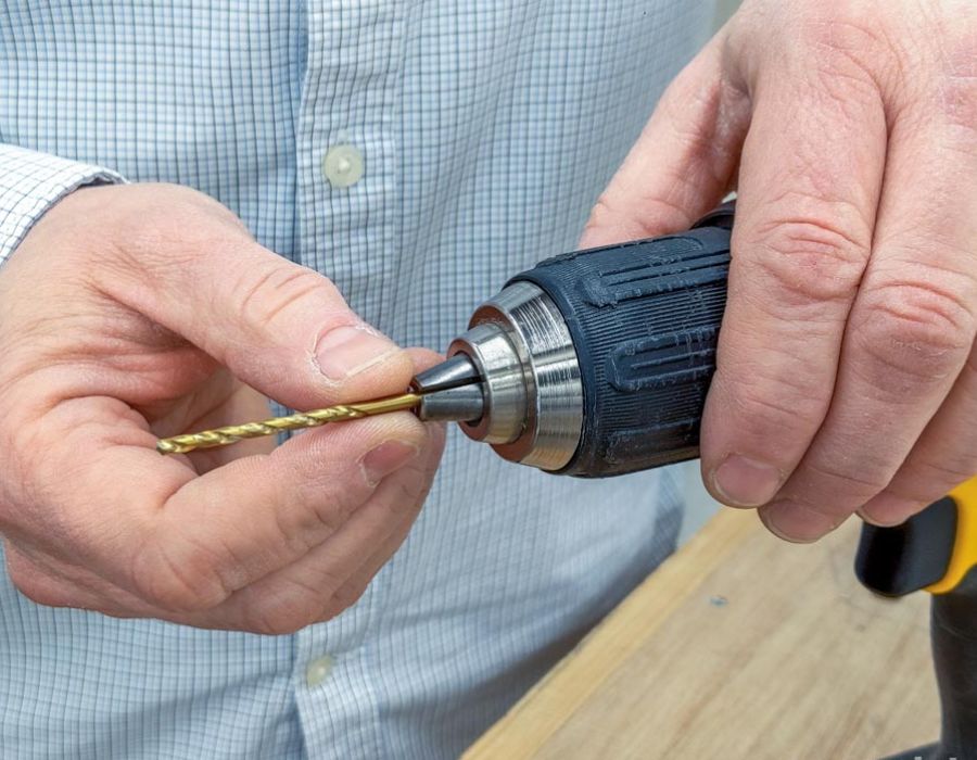 man attaching mini drill bit to drill