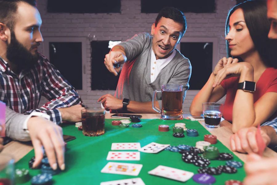 a group of individuals gathered around a rectangular poker table