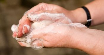 person washing spray foam off hands